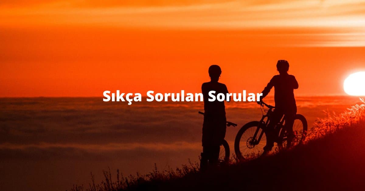Gün batımında velosipedləri ilə dayanan iki nəfər